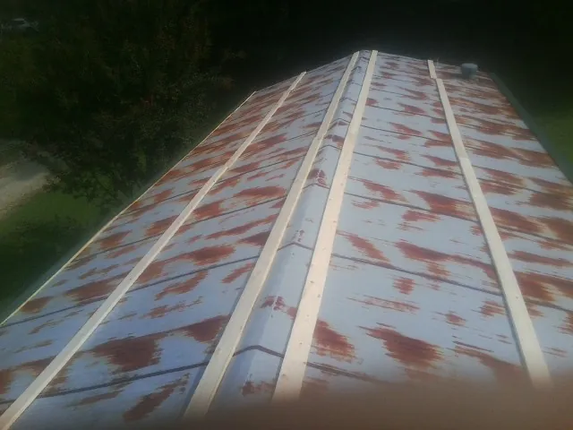 Rusted metal roof panels with new wood purlins before replacement — Storm Damage Roof Repair in Wilkesville by Roofing Brothers