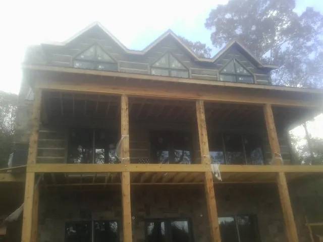 Dormers and porch framing on a large log home under construction — Roof Coating work by our crew in Wilkesville